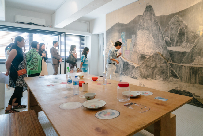 (Front) William Lim, 54:10: Artist’s table, 2011. (Right) Lam Tung-Pang, The Huge Mountain, 2011. Courtesy of Living Collection.
