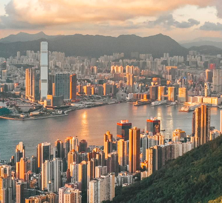 從太平山頂俯瞰沐浴在夕陽金光中的維多利亞港及香港摩天大樓全景。