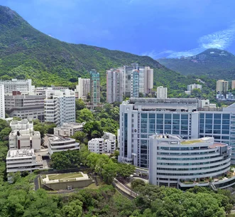 港大李嘉誠醫學院沙宣道校園全景，依山而建，周圍綠樹環繞，天空晴朗藍天。