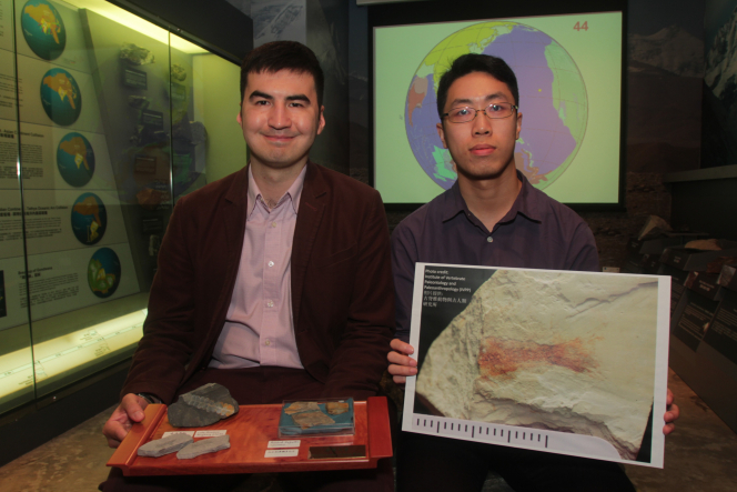 謝子旗先生(右)和文嘉棋博士(左)分別展示一條曾居於荔枝莊、約1億4千7百萬年前的副狼鰭魚化石圖片，以及其他同屬恐龍年代的化石。