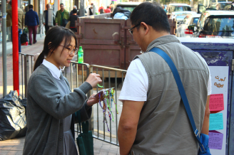 Student distributing heart-shaped charms